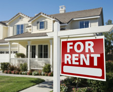 a for rent sign in front of a two story home